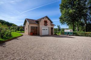 ein Haus mit einer Auffahrt mit einer Garage in der Unterkunft Le Clos des Pervenches in Jassans-Riottier