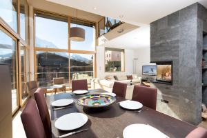 Chalet Couttet - Chamonix All Year في شامونيه مون بلان: غرفة طعام مع طاولة ومدفأة