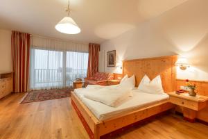 a bedroom with a large bed and a couch at Steinegger in Appiano sulla Strada del Vino