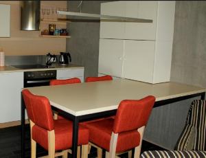 a kitchen with a table and red chairs at Kaluri Residence in Kuressaare