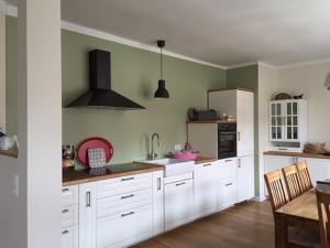 eine Küche mit weißen Schränken und grünen Wänden in der Unterkunft Ferienhaus Niemtsch in Niemtsch