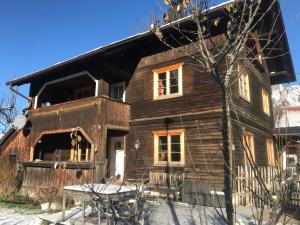 ein altes Holzhaus mit einem Tisch davor in der Unterkunft Tiroler Knusperhäuschen in Tannheim