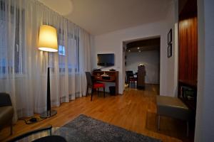 ヘルゴラントにあるHotel Quisisana & Appartements Quisiのリビングルーム(テーブル、ランプ付きデスク付)