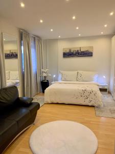 1 dormitorio con cama blanca y sofá en Casa Nataliya, via tampori 8 6503 Bellinzona en Bellinzona