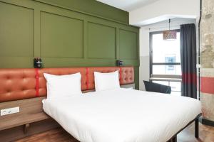 a hotel room with two beds and two lamps at Generator Madrid in Madrid