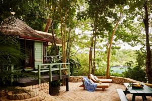 eine Veranda eines Hauses mit einem Tisch und Stühlen in der Unterkunft GoldenEye in Oracabessa