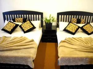 two beds with pillows on them in a bedroom at Hotel Grand Sun Inn in Nuwara Eliya