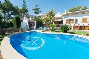 a large blue swimming pool in front of a house at Villa Anfos in Sa Ràpita