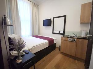 ロンドンにあるザ ロイヤル チュラン ハイド パーク ホテルのベッド、テーブル、鏡が備わる客室です。