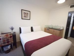 Un pat sau paturi într-o cameră la The Royale Chulan Hyde Park Hotel
