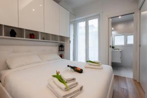 ein Schlafzimmer mit einem weißen Bett und Handtüchern darauf in der Unterkunft BnButler Friuli, 24 - Porta Romana Apartment in Mailand