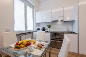 eine Küche mit einem Tisch und einer Obstschale darauf in der Unterkunft BnButler Friuli, 24 - Porta Romana Apartment in Mailand