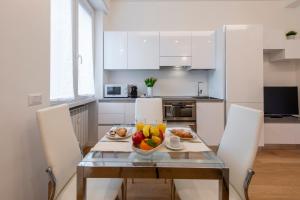 eine Küche mit einem Tisch und einer Obstschale darauf in der Unterkunft BnButler Friuli, 24 - Porta Romana Apartment in Mailand