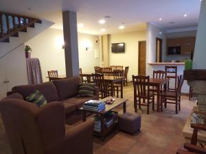 uma sala de estar com um sofá, uma mesa e cadeiras em OTXOENEA em Irun