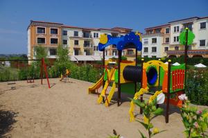 einen Spielplatz mit Spielgeräten im Sand in der Unterkunft Lily Beach Resort in Sozopol