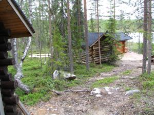 a log cabin in the woods next to a forest at Ukonloma Cottages in Rovaniemi