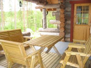 a wooden table and chairs on a porch of a cabin at Ukonloma Cottages in Rovaniemi