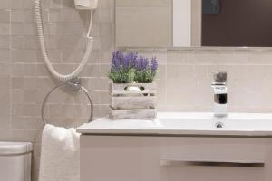 a bathroom with a sink and a shower with purple flowers at Suite Place Barcelona Còrsega in Barcelona +288 photos