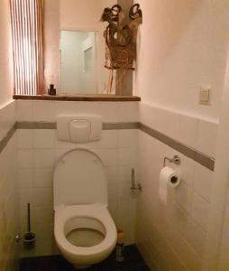 ein kleines Bad mit einem WC und einem Spiegel in der Unterkunft Have a nice stay! - Strand Vakantiehuis Noordwijk in Noordwijk aan Zee + 14 Fotos