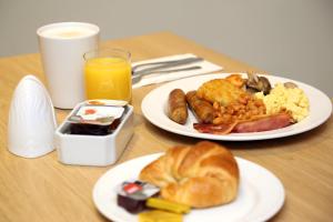 a table with two plates of breakfast food and orange juice at Shore View Hotel in Eastbourne