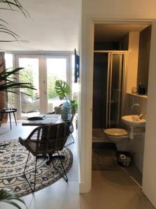een badkamer met een tafel, een wastafel en een toilet bij La Casita Alta Free Parking in Noordwijk aan Zee
