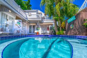 a swimming pool in front of a house at Seascape Tropical Inn in Key West
