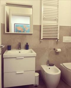 une salle de bain avec un lavabo, des toilettes et un miroir dans l'établissement LOVELY MILANO - Brand new stylish apartment in Navigli Area, à Milan 14 autres photos