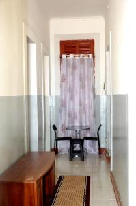 a living room with a table and a window at Ana Chaves Residence in São Tomé