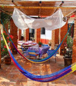 una hamaca en un patio con mesa y sillas en Hotel Casa Alvarada, en Comala