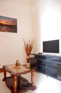 a living room with a coffee table and a flat screen tv at Ana Chaves Residence in São Tomé