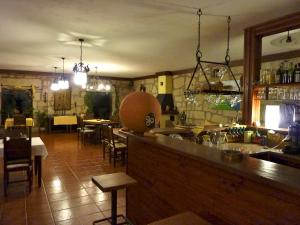 Oficina Do Joe Guesthouse في Outeiro: بار في مطعم مع طاولة وكراسي