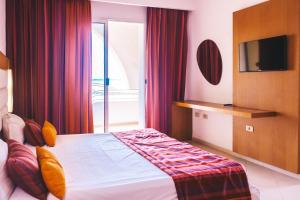 a hotel room with a bed and a television at Skanes Sérail in Monastir