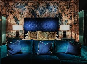 niebieską kanapę w sypialni z łóżkiem w obiekcie Great Fosters - Near Windsor w mieście Egham