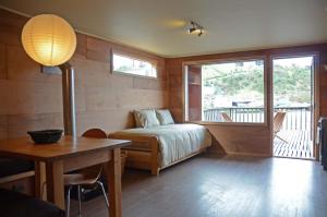 um quarto com uma cama, uma mesa e uma janela em Palafito Azul Apart Hotel em Castro
