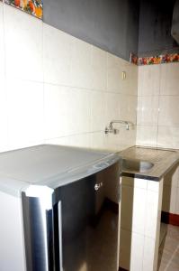 a kitchen with a sink and a stainless steel refrigerator at Ana Chaves Residence in São Tomé +4 photos