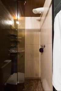 y baño con ducha y puerta de cristal. en MAN CAVE HOSTEL, en Belo Horizonte