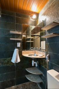 uma casa de banho com um lavatório e um espelho em MAN CAVE HOSTEL em Belo Horizonte