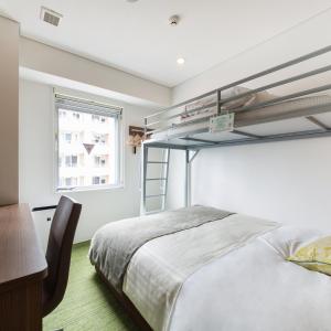 a bedroom with a bunk bed and a desk at Super Hotel Premier Hakataeki in Fukuoka