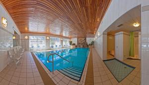 a large swimming pool in a building at Hotel Twengerhof in Tweng +16 photos