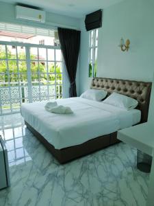 a bedroom with a large bed and a balcony at Promporn Boutique Hotel in Nan