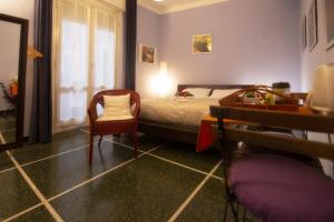ジェノヴァにあるIl Riposo del Guerriero Guesthouseのベッドルーム1室(ベッド1台、椅子、テーブル付)