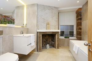 uma casa de banho com um lavatório e uma lareira em JOIVY Elegant 2BR Home at The Heart of the Royal Mile em Edimburgo