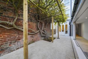 an alleyway with a brick wall and trees at Eton House-Stunning-Castle views-5Bed-Free-Parking in Eton