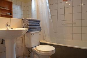 a bathroom with a toilet and a sink and a tub at Palafito Azul Apart Hotel in Castro