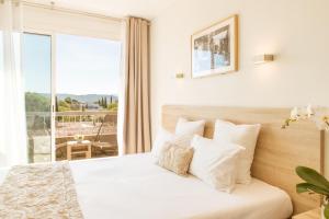 a bedroom with a bed with a view of a balcony at Le Concorde in Aix-en-Provence