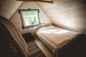 um quarto num chalé de madeira com uma cama e uma janela em Mesi Tare Guesthouse em Varnja