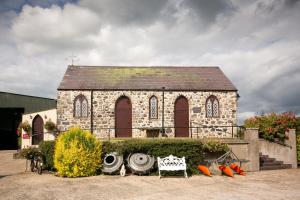 an old stone church with a bench in front of it at Brookhall Cottages in Lisburn