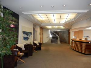 eine Lobby mit Stühlen und Treppen in einem Gebäude in der Unterkunft Hotel Schweizerhof Pontresina in Pontresina