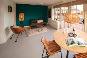 uma sala de estar com uma mesa e cadeiras e um sofá em Saenliefde em Wormer