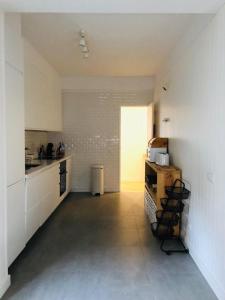 a kitchen with white cabinets and a table in it at Apartamento espaçoso e confortável no centro do Montijo in Montijo
